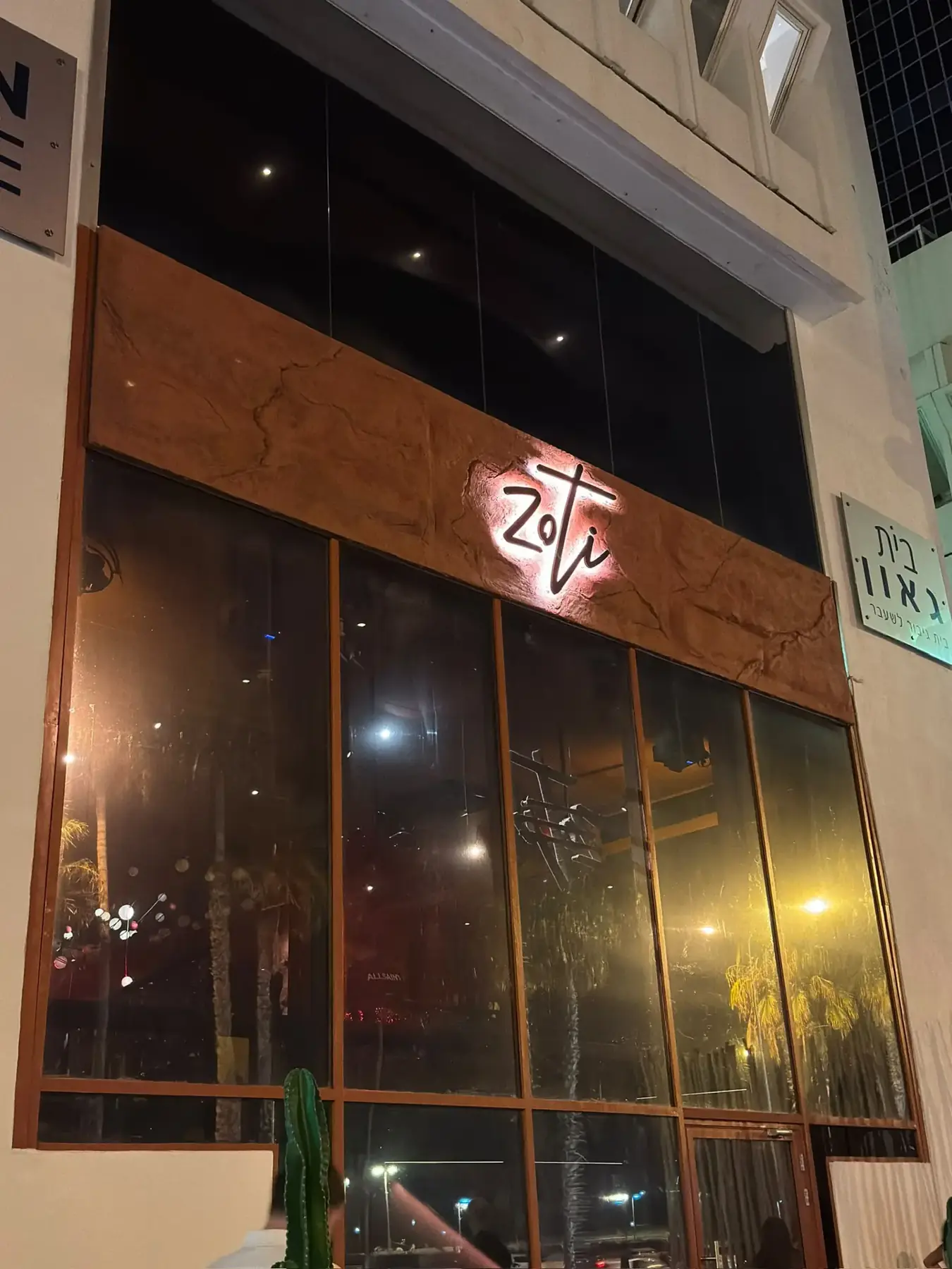 ZOTI: לוגו עם הילה אחורית על חזית המסעדה