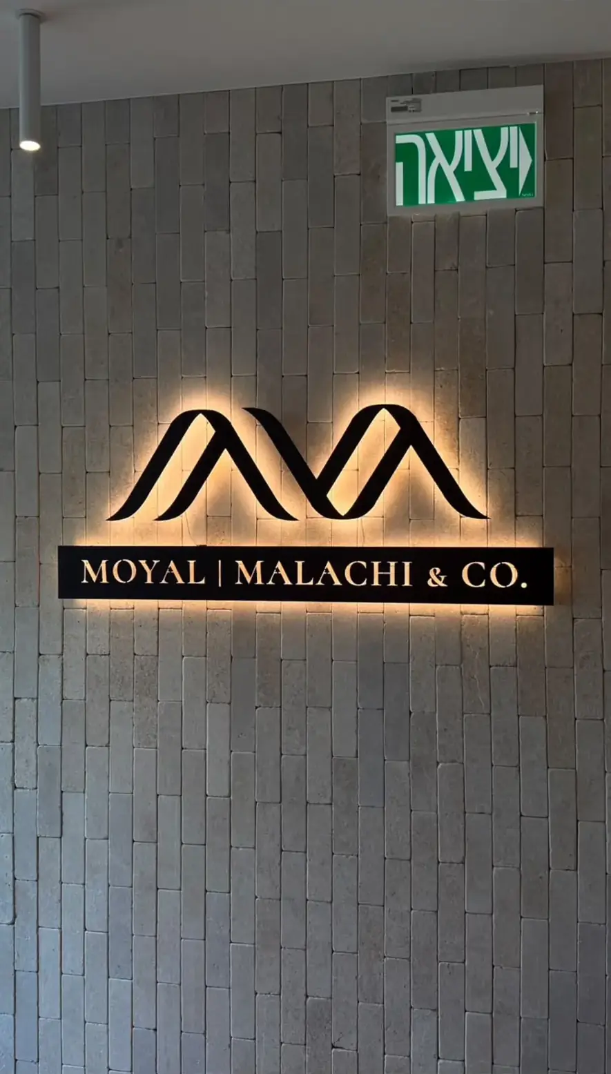 MOYAL MALACHI & CO.: לוגו ואותיות עם הילה אחורית על הקיר