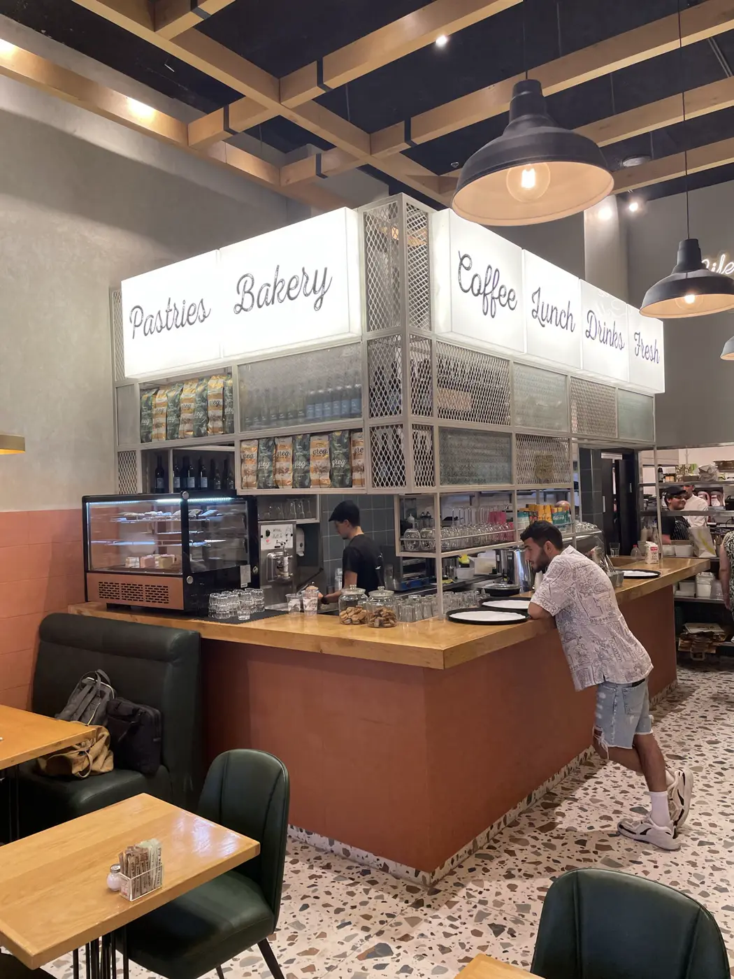 ארגזי פרספקס לבנים עם כתב יד (Pastries, Bakery, Coffee...) לאורך הבר של בית קפה