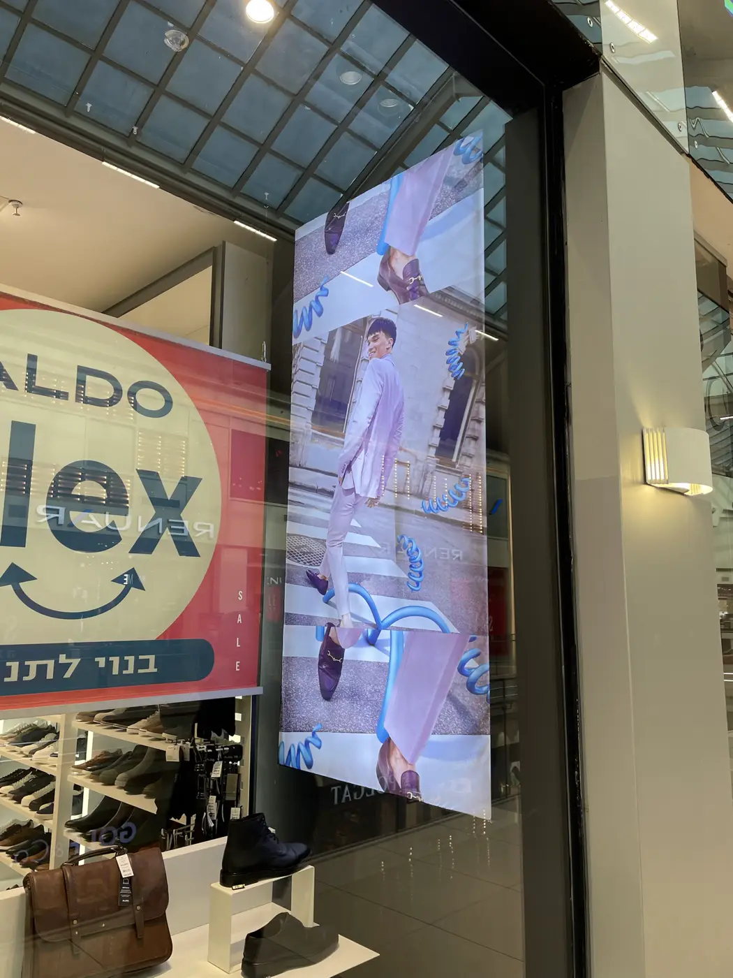 ארגז פריימלס אנכי מאחורי זכוכית הויטרינה, תמונת קמפיין של גבר בחליפה